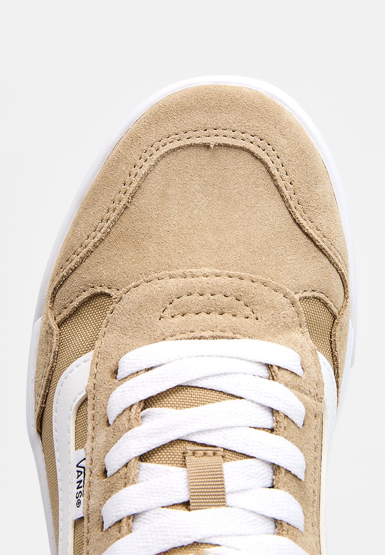 Zapatillas de ante beige con cordones blancos, acentos de malla y un logo característico. Diseño de punta redondeada y una suela intermedia acolchada.