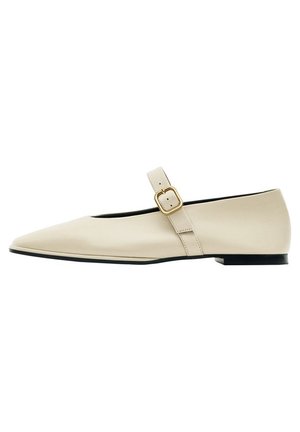 Beige spids tå flad sko med en enkelt justerbar rem og guldlås, med lav sort hæl og glat læder finish.