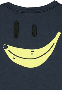 Námořnické tričko s grafikou žlutého banánu s úsměvem, černými vyšitými očima a jednoduchými linijními detaily. Měkký bavlněný materiál.