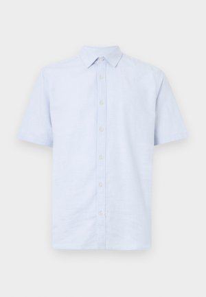 Chemise courte en coton de couleur bleu clair. Possède un devant à boutons, un col pointu et des coutures visibles le long des coutures.