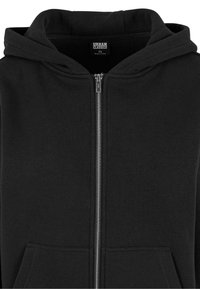 Felpa nera con zip realizzata in tessuto morbido. Presenta un ampio cappuccio, tasche frontali e una chiusura con zip metallica. Design semplice e funzionale.
