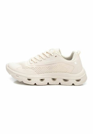 Zapatillas de color beige claro con parte superior de malla, suela texturizada con patrones recortados y cordones planos para un ajuste seguro.