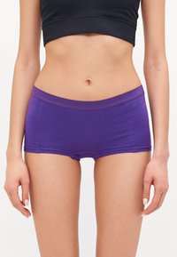 Lilla bomullsshorts med en bred, glatt midjebånd, som har en tettsittende passform og sidesømmer. Enkelt design, uten mønstre eller ekstra utstyr.