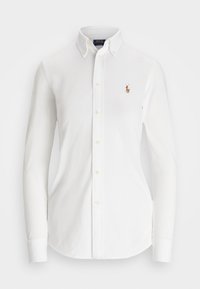 Chemise blanche à manches longues boutonnée avec col boutonné et petit logo brodé d’un joueur de polo sur la poitrine gauche.