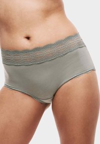 Slip hipster in cotone verde chiaro con una vita in pizzo ondulato. Il tessuto è morbido e il pizzo presenta dettagli intricati.