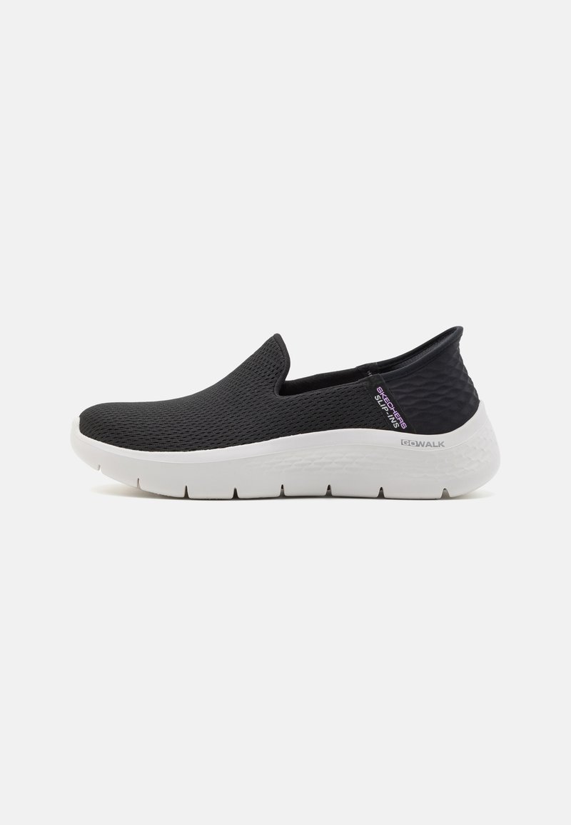 Czarne buty wsuwane wykonane z siateczkowego materiału, z białą gumową podeszwą o teksturowanym wzorze i minimalnym logo z boku.