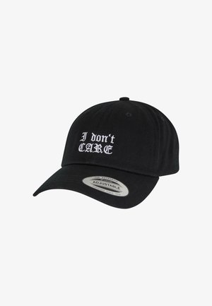 Casquette noire à visière incurvée, avec le texte brodé blanc "Je m'en fiche." Sangle ajustable à l'arrière, fabriquée en matériau textile.