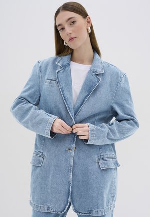 Hele sinine, üle suuruse denim bleiser ühe nupu kinnitusega, suuremate taskutega ja vabalt istuva lõikega. Sile tekstuur ja klassikaline kraediisain.