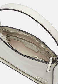 Beżowa skórzana torebka na ramię z zamkiem błyskawicznym na górze, o gładkiej fakturze, z pojedynczym uchwytem i wewnętrzną kieszonką zamykaną na zamek.