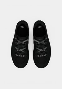 Baskets noires avec une tige en textile lisse, un embout perforé et des lacets gris à motifs. Dotées d'un talon renforcé et d'un branding discret.