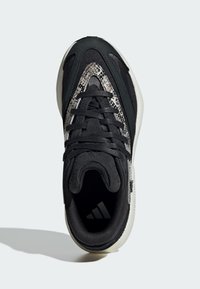 Čierne športové tenisky s textúrovaným hadím vzorom, z materiálu sieťoviny a kože, so šnurovaním a kontrastnou bielou podrážkou.