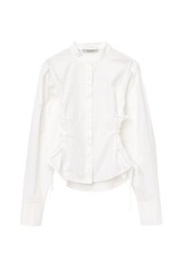 Camicia bianca a maniche lunghe, in cotone, colletto alto, chiusura frontale con bottoni, dettagli arricciati ai lati, orlo curvo.