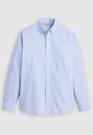 Svetlomodrá košeľa s dlhým rukávom na gombíky vyrobená z bavlny, s klasickým golierom a jemnou značkovou výšivkou na ľavom prsnom vrecku.