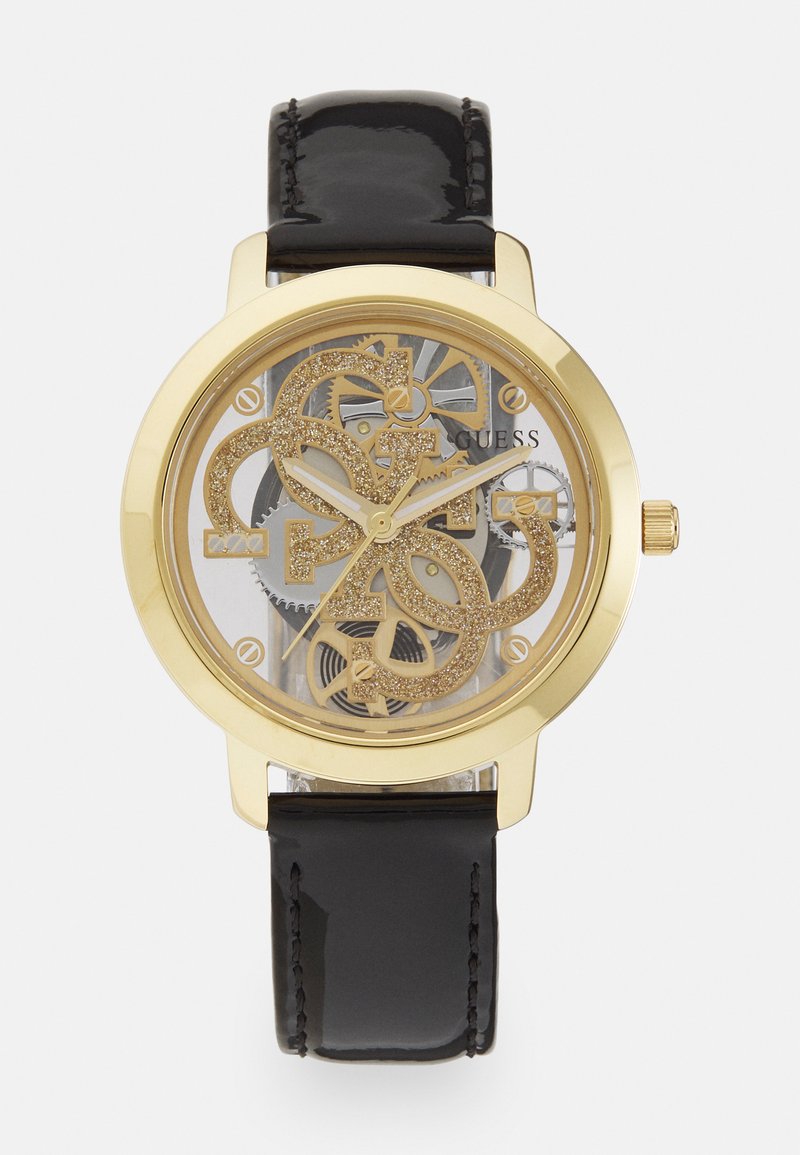 Orologio d'oro con quadrante trasparente che mostra ingranaggi intricati; cinturino in pelle nera lucida; grande design del logo luccicante.