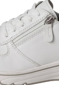 Valkoinen nahkakengät, joissa on teksturoitu pinta, nauhakiinnitys, sivu zippiväline ja vaaleanharmaa kumipohja. Korostetut saumat näkyvät.