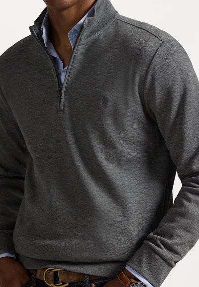 Γκρίζα πουλόβερ με σχέδιο quarter-zip, φτιαγμένο από μαλακό ύφασμα, με διακριτικό λογότυπο, μακριά μανίκια και ριμπ ύφανση στο τελείωμα.