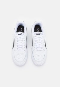 Sneaker bianche con dettagli neri, dotate di una tomaia in pelle liscia, punta rotonda, dettagli perforati e lacci piatti. Logo Puma sulla linguetta.