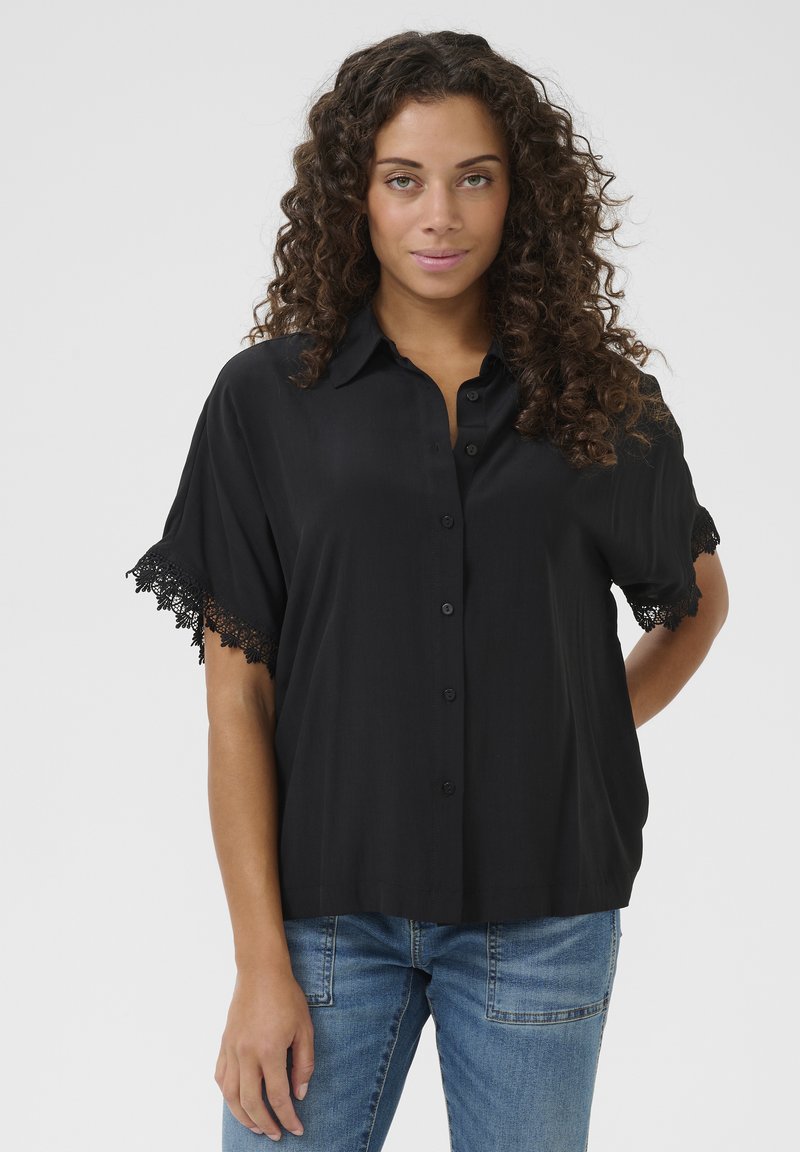 Zwarte overhem shirt met korte mouwen en kantafwerking. Gemaakt van soepele stof, heeft een losse pasvorm en een klassiek kraagontwerp.