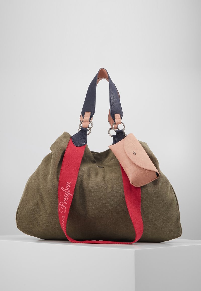 Olive green canvas bag with a gathered design, navy and pink leather straps, and a small pink leather pouch attached. Red accent strap with text.