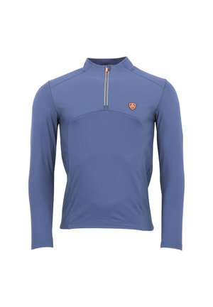 Haut à manches longues bleu, avec un col zippé mi-hauteur et un panneau sur la poitrine. Présente un petit logo orange et une texture de tissu lisse et structurée.