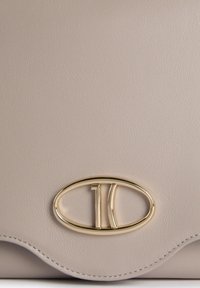 Borsa a mano in pelle beige con logo ovale dorato con "10" al centro, texture liscia e bordo ondulato.