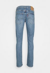 Vue arrière d'un jean Levi's en denim bleu avec des jambes droites, deux poches arrière et un patch en cuir de la marque à la ceinture.