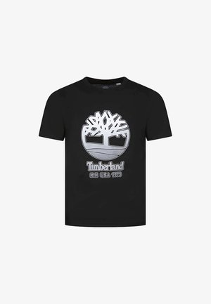 T-shirt en coton noir avec un graphique argenté représentant un logo d'arbre, accompagné du texte "Timberland" et "N.H. USA 1973" en dessous. Manches courtes et col rond.