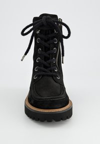 Botte de cheville en suède noir avec lacets à l'avant, zip sur le côté, semelle en caoutchouc et semelle intermédiaire tan. Présente des œillets en métal argenté et des lacets texturés.