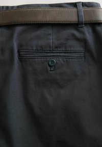 Black fabric trousers featuring a dark brown leather belt, a rear pocket with a button closure, and subtle stitching details.