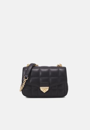 Sort quiltet læderhåndtaske med guldkæde-rem og trekantet guldlås indgraveret med Michael Kors-logo på frontlåget.