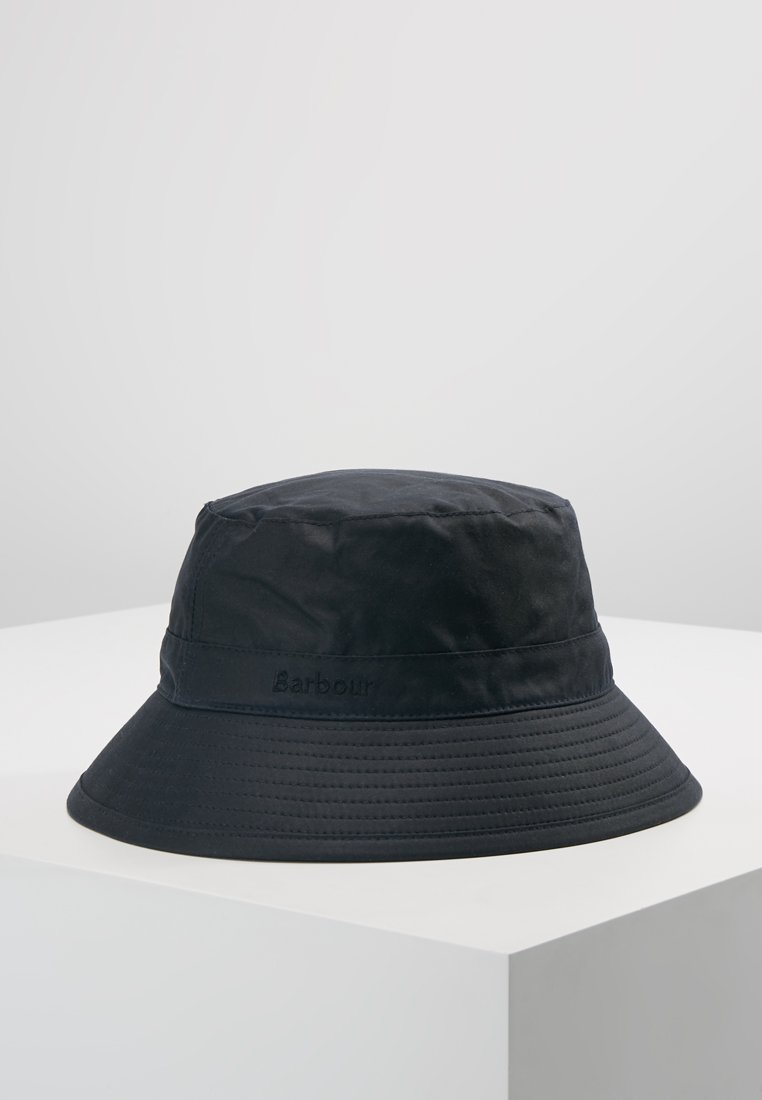Black bucket hat made of waterproof material. Features a wide brim and embroidered logo on the side. Smooth texture with subtle sheen.