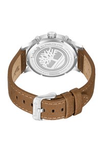 Orologio Timberland con cassa in acciaio inossidabile e cinturino in pelle marrone. Presenta una fibbia argentata e il logo dell'albero inciso sul retro della cassa.