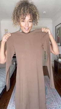 Vestido castanho de mangas longas, feito de um tecido suave, com decote redondo e silhueta ajustada. As mangas têm um ligeiro efeito de abertura nos punhos.