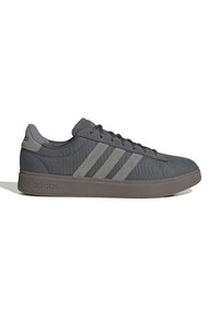 Sneaker basse di colore grigio scuro Adidas con tre strisce grigio più chiare, lacci sul davanti, suola imbottita e logo Adidas sul tallone e sulla suola.