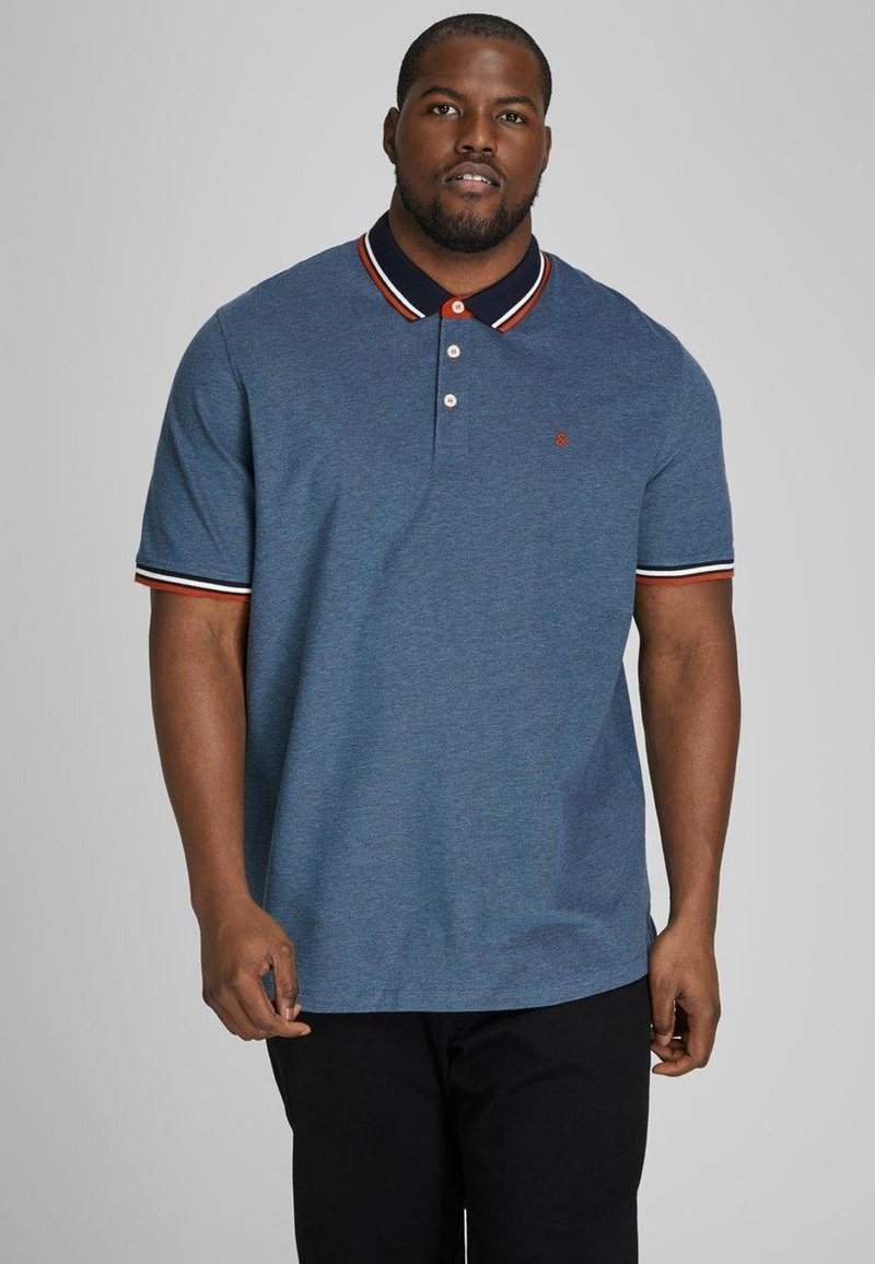 Blue polo shirt with a collar, white and red striped accents on sleeves, three-button placket, and small logo on the chest.
