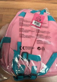 Roze rugzak met aqua blauwe banden en accenten, gemaakt van duurzaam materiaal. Beschikt over verstelbare banden en een decoratief label. Duidelijke verpakking.