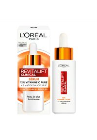 Sérum L'Oréal Paris Revitalift Clinical dans un flacon blanc avec un compte-gouttes, des accents dorés, et une étiquette circulaire orange sur une boîte. 12% de vitamine C.