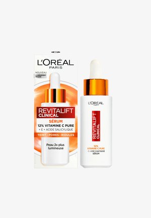 Sérum L'Oréal Paris Revitalift Clinical dans un flacon blanc avec un compte-gouttes, des accents dorés, et une étiquette circulaire orange sur une boîte. 12% de vitamine C.