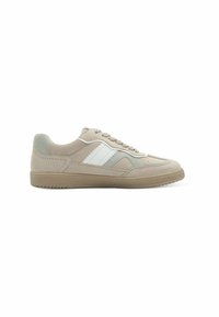 Beige sneaker with a textured finish, white side stripe, and a contrasting grey heel. Features a lace-up design and rubber sole.