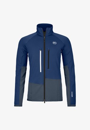 Blau-graue Jacke mit langen Ärmeln und hohem Kragen, vorne mit Reißverschluss, zwei vertikalen Reißverschlusstaschen auf der Brust und Logo auf der linken Seite.