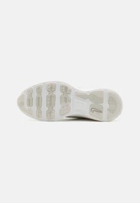 Semelle extérieure de sneaker blanche en caoutchouc texturé avec des formes variées, des rainures et un détail de logo. Conçue pour l'adhérence et la durabilité.