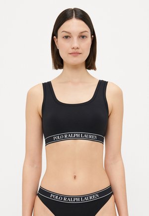 Melnā sporta bralette ar kvadrātveida dekoltē un platām siksnām. Iekļauj zīmola elastīgo joslu ar tekstu "POLO RALPH LAUREN" baltā krāsā.