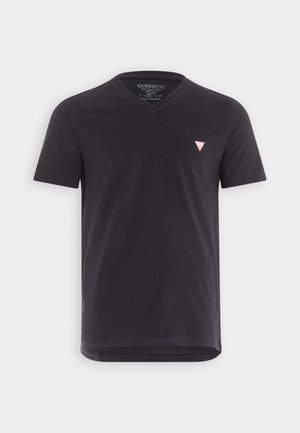 Camiseta de algodón negra con cuello en V, mangas cortas y un pequeño logotipo triangular rojo en el pecho. Textura suave y dobladillo recto.