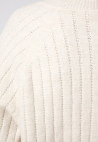 Witte gebreide trui met verticale geribbelde textuur en een subtiele glans, ronde halslijn en een relaxte pasvorm. Zachte stof met een knusse uitstraling.