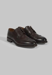 Donkerbruine leren oxford schoenen met een brogue-design, met decoratieve perforaties, platte veters en een lage, gestapelde hak.