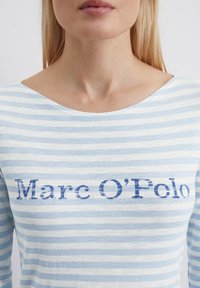 Blau-weißer, gestreifter Langarmoberteil mit weitem Ausschnitt und dem Text "Marc O'Polo" in Dunkelblau unter dem Kragen.