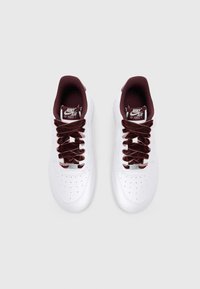 Bijele Nike Air Force 1 tenisice s maroon baršunastim vezicama, perforiranim prstom, podstavljenim ovratnikom i oznakom na jeziku.