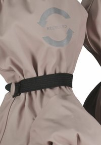 Kurtka z materiału z recyklingu w miękkim różowym kolorze z czarnym elastycznym paskiem ściągającym w talii. Na tkaninie umieszczono odblaskowe srebrne logo recyklingu.