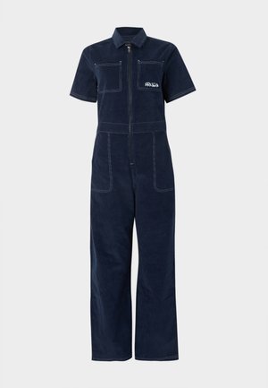 Salopetă bleumarin cu mâneci scurte, fermoar frontal, două buzunare la piept, două buzunare laterale și logo-ul alb RVCA pe buzunarul stâng de la piept.