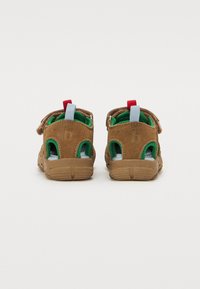 Braune Wildleder-Sandalen mit grünem Innenfutter und Gummisohlen, ausgestattet mit verstellbaren Riemen und Rückziehlaschen in Rot und Blau.